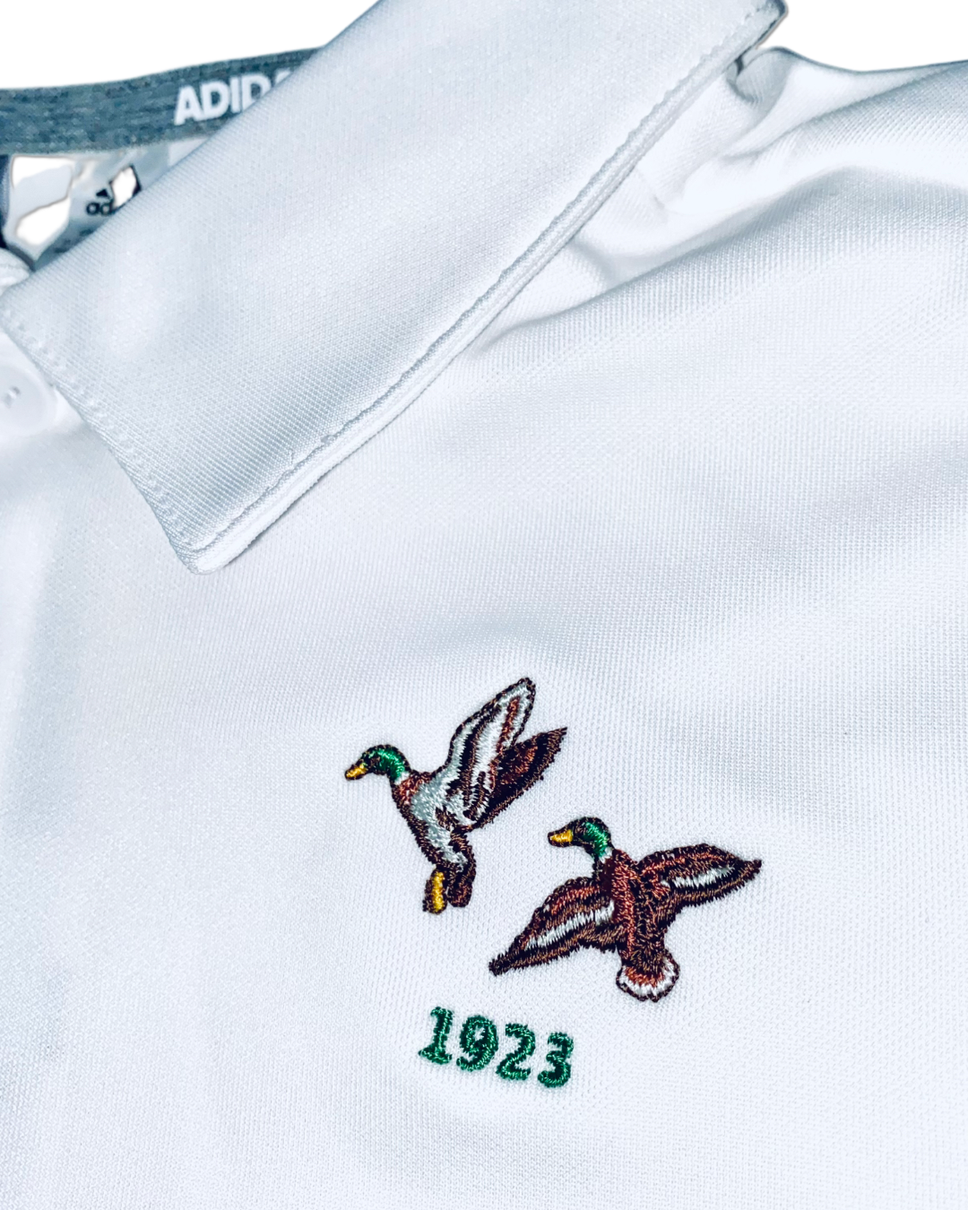 Adidas Kids Boys Three Stripe Golf Polo Shirt , close up of embroidered logo at the chest 