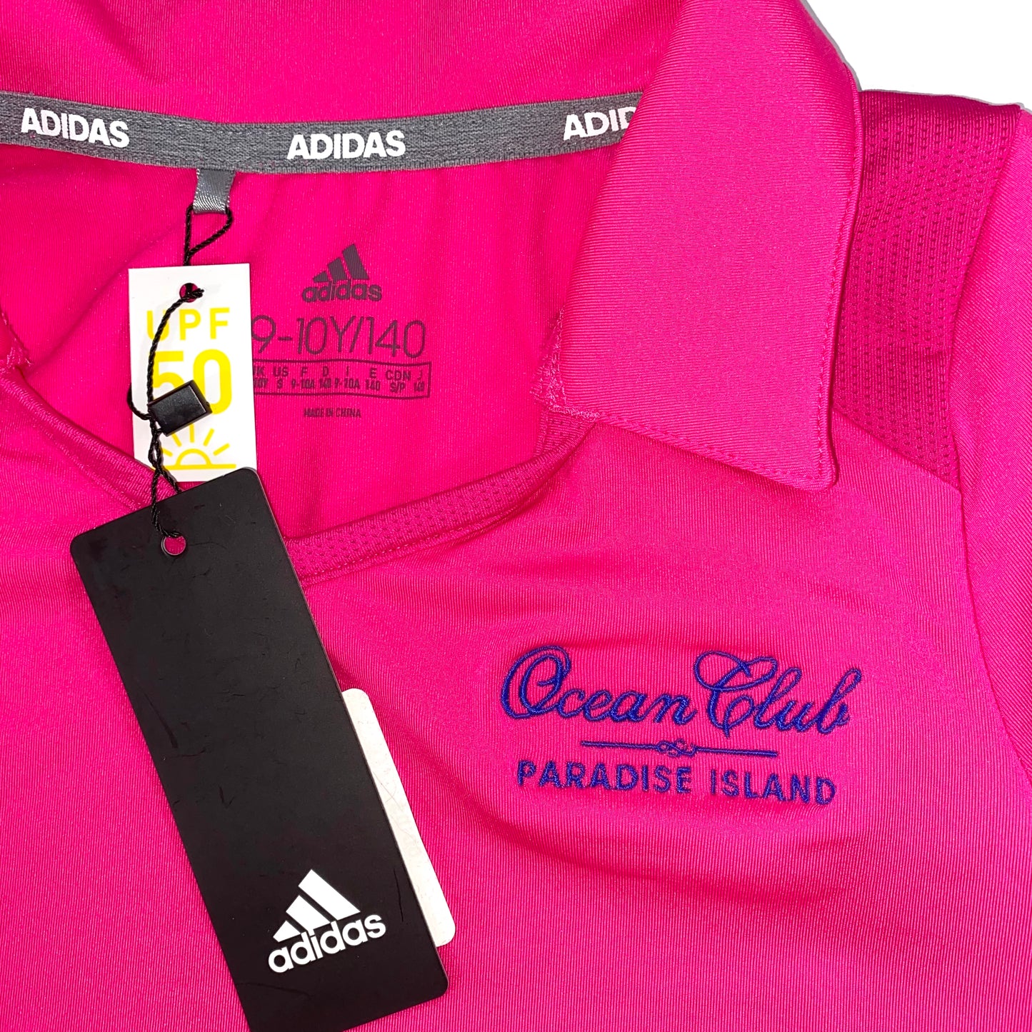 Adidas Girls Ruffled Golf Dress front V-neck and embroidered Ocean Club Paradise Island logo on chest 